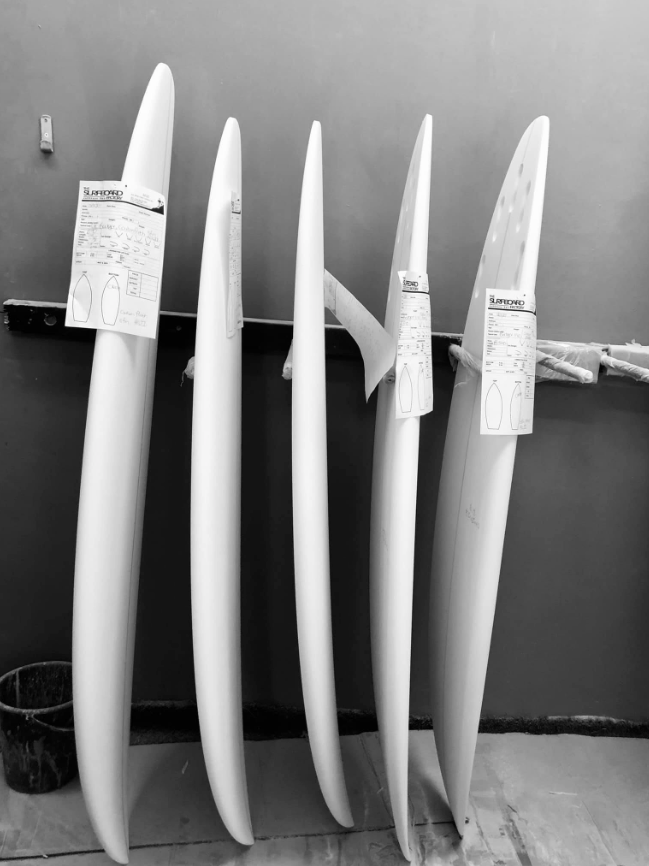 Thys hand-sanding a board in the bay