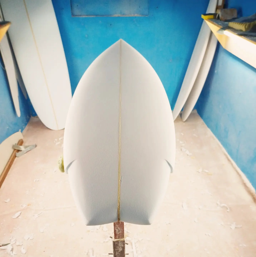 A freshly shaped white blank in the Rebel shaping bay